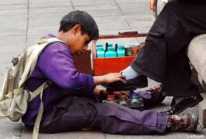 Niño trabajando en Quito limpiando botas